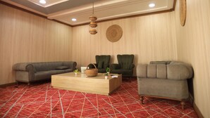 A room with two sofas, a wooden coffee table, and a hanging light fixture.