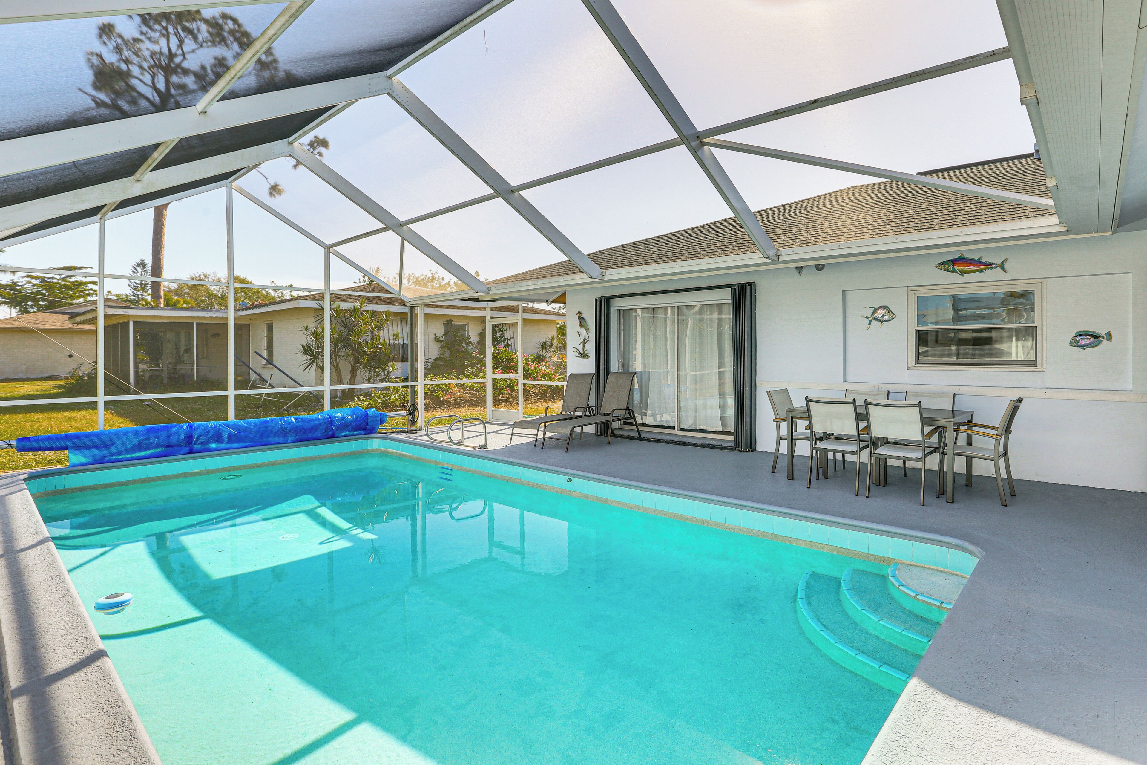 Una piscina coperta con un'area solarium, comprensiva di sedie e tavolo.