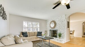 A living room with a sofa, a coffee table, a fireplace, and a dining area. - 4 Mi to Lakes Park: Family Home in Fort Myers! (Fort Myers)