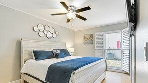 A bedroom with a wooden bed, a ceiling fan, a window with blinds, and a wall-mounted TV. - 4 Mi to Lakes Park: Family Home in Fort Myers! (Fort Myers)