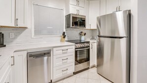 A modern kitchen with white cabinetry, stainless steel appliances, and a dishwasher. - 'wright by the Beach': Hilton Head Condo w/ Perks (Hilton Head Island)