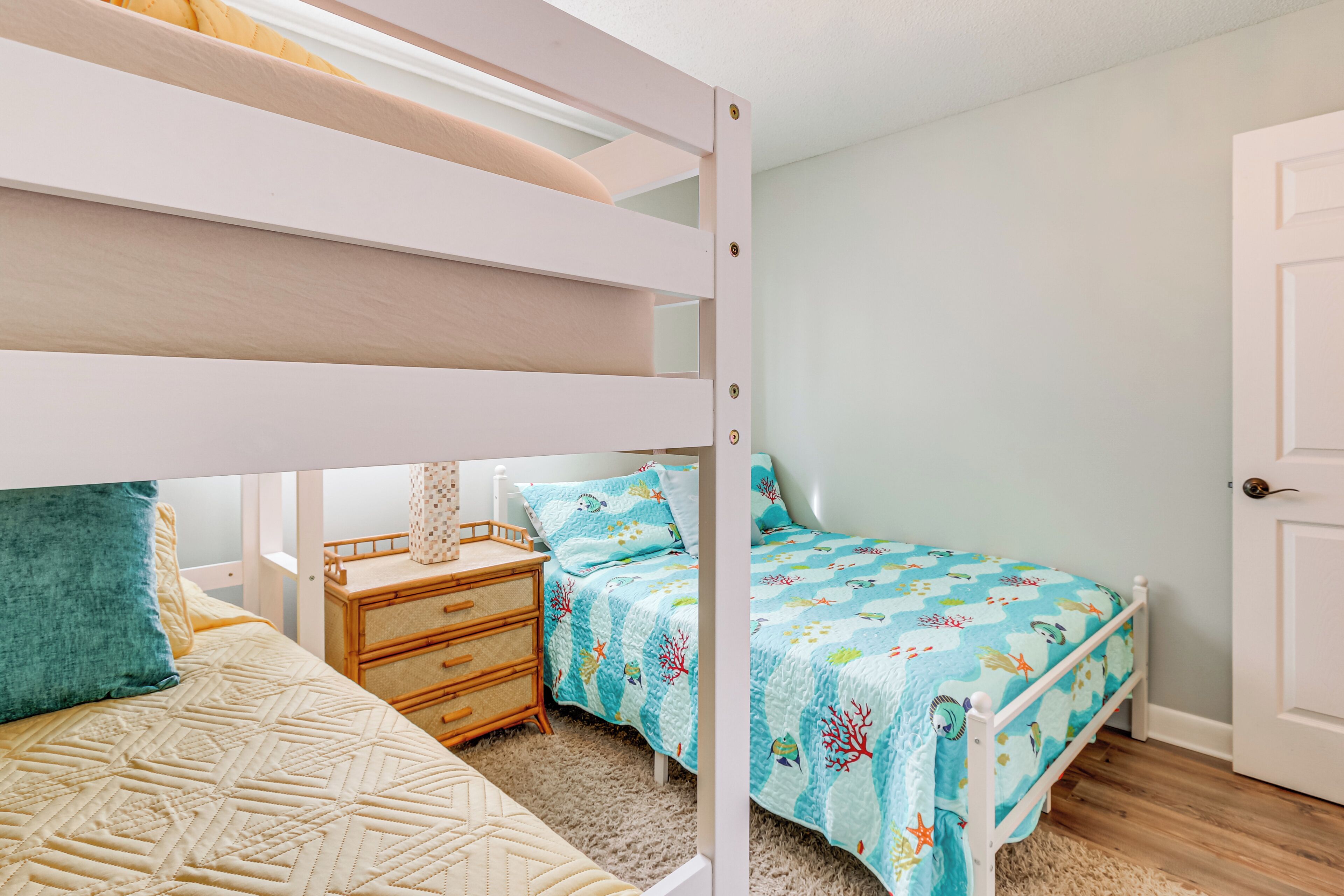 A bedroom with bunk beds, a bedside table, and a nightstand.