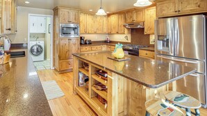 A modern kitchen with wooden cabinets, stainless steel appliances, and a granite countertop. - Bend Golf & Country Club Vacation Home (Bend)