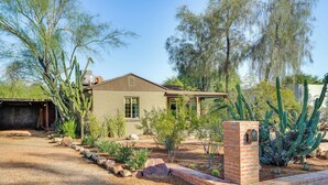 Une maison de plain-pied aux murs en briques, entourée d’un jardin aménagé où l’on trouve différentes espèces de cactus et d’arbustes.
