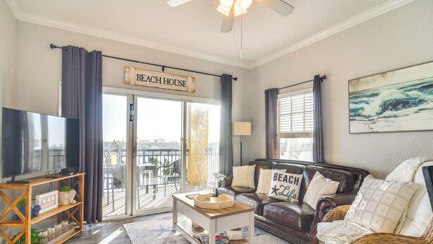 A living room with a television, a coffee table, a sofa, and a sign that reads "Beach House". - Short Walk to Bay & Ocean: Treasure Island Condo (Treasure Island)