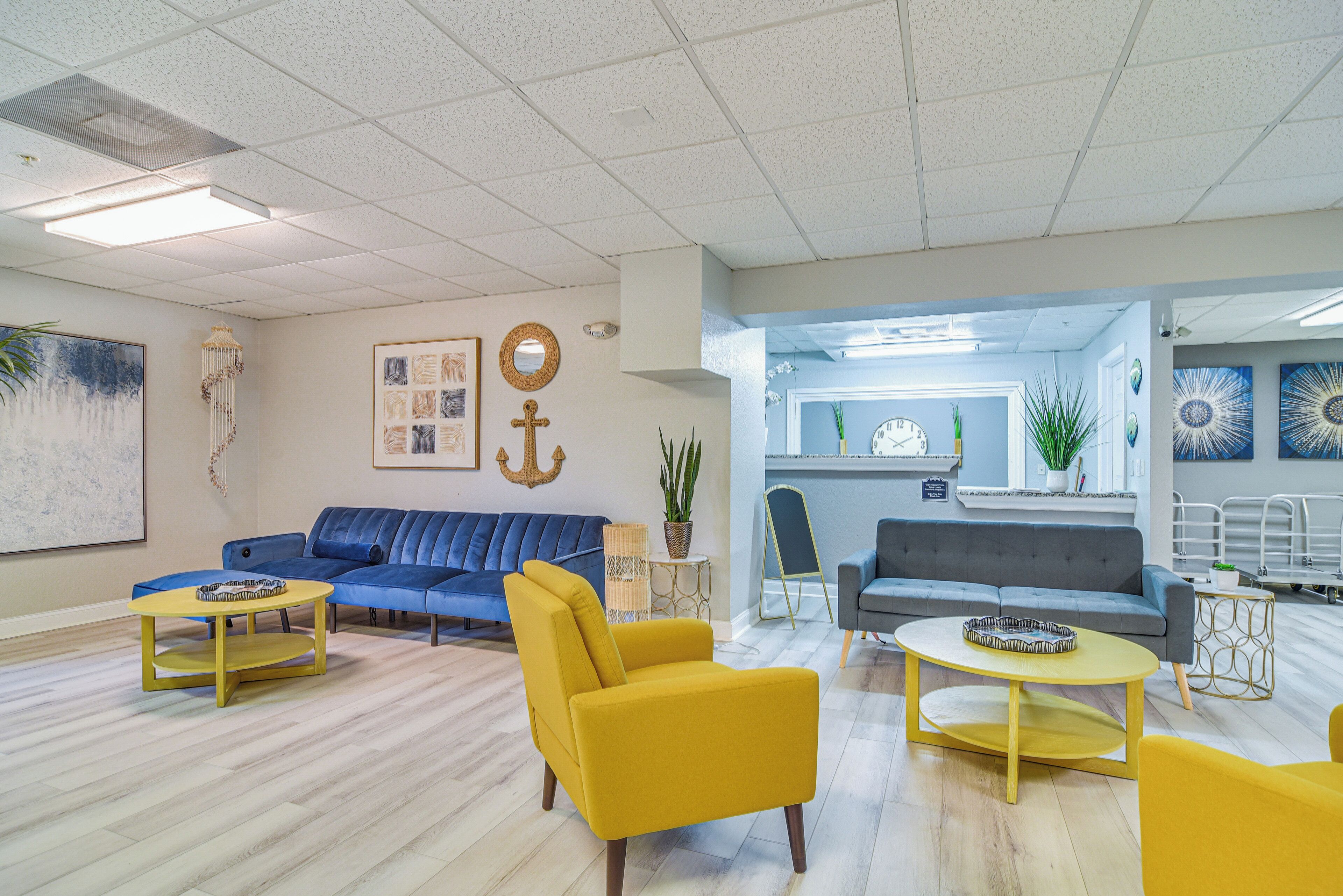 A modern living room with two sofas, a yellow armchair, and a round coffee table.
