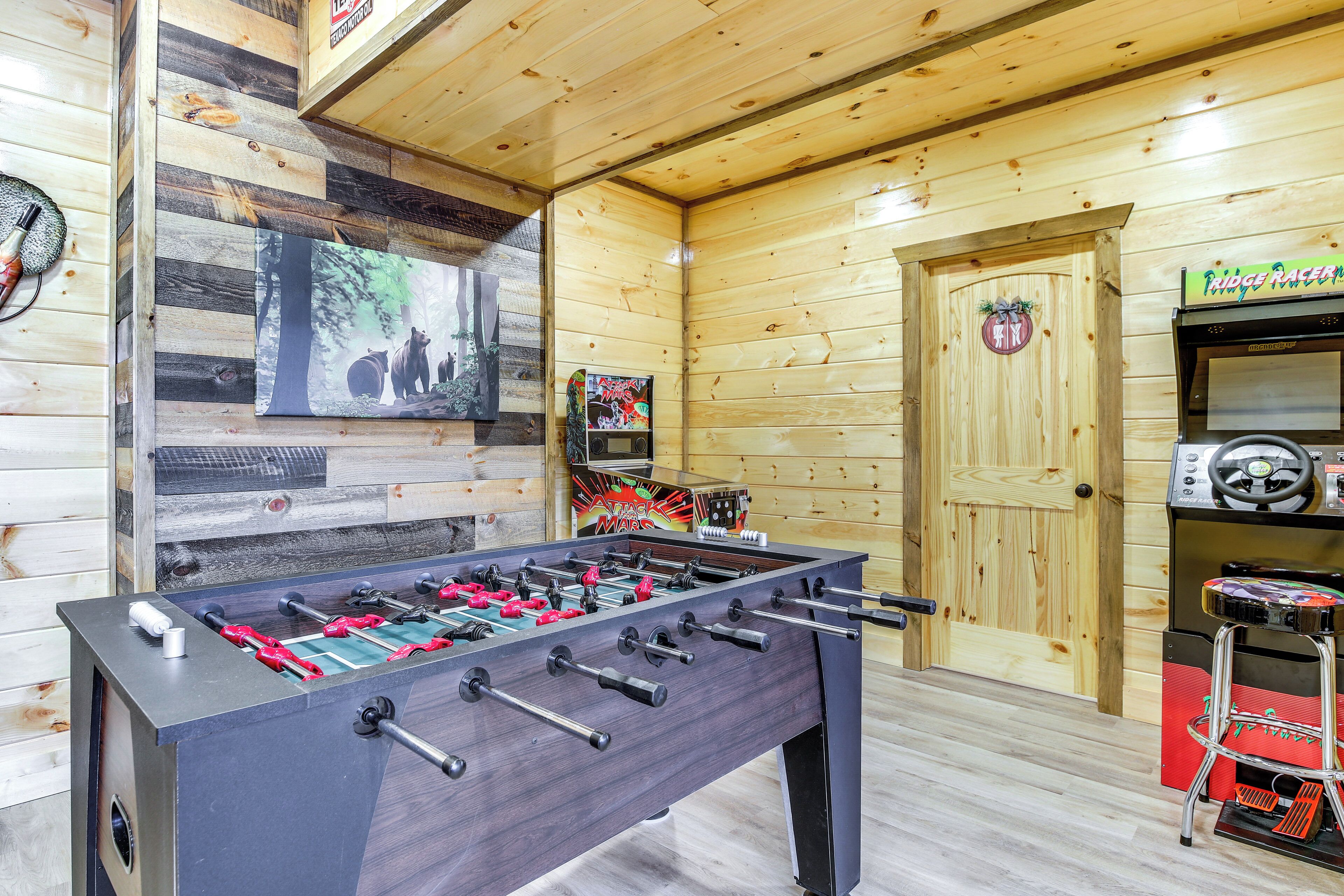 A foosball table in a wooden room with a door and a sign above it.