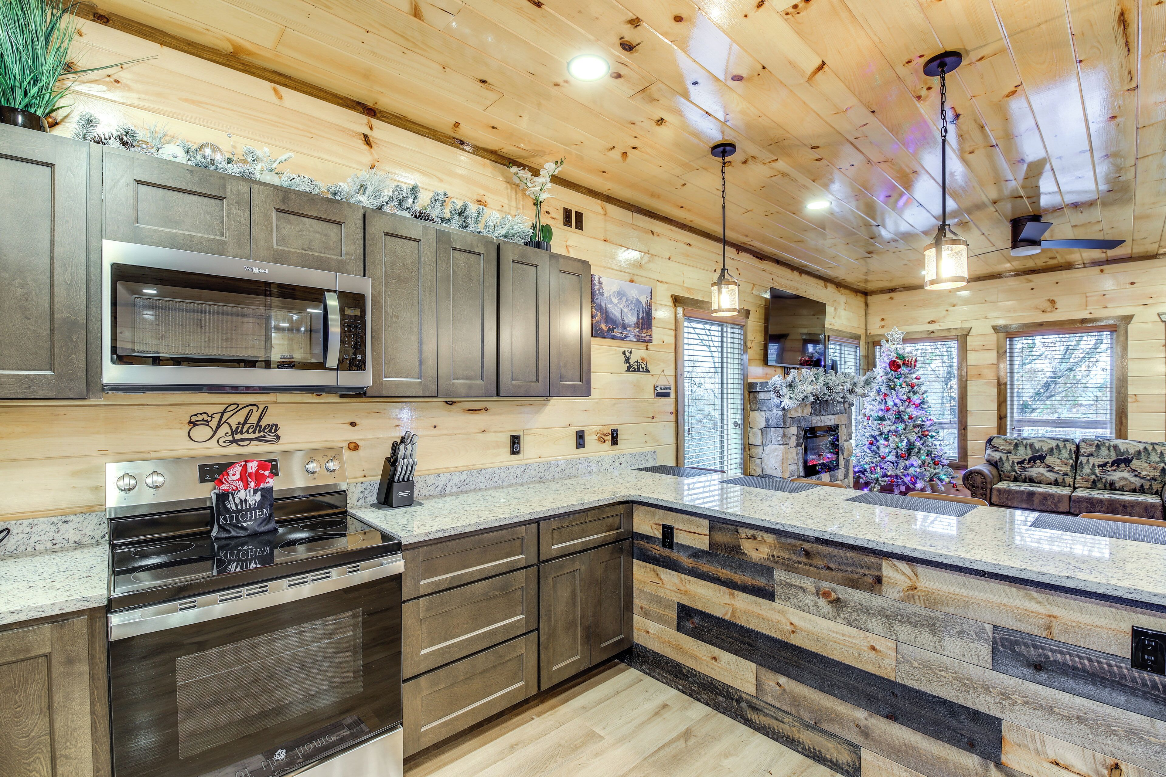 A kitchen with a built-in microwave, oven, and granite countertop.