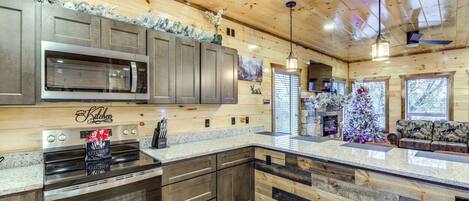A kitchen with a built-in microwave, oven, and granite countertop.