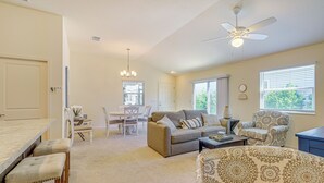 A spacious living room with a sofa, armchairs, a dining area, and a ceiling fan. - Golf, Shop & Unwind: Lovely Home in The Villages! (Wildwood)