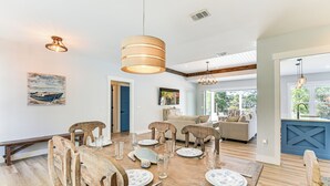 A dining area with a wooden table set for six, surrounded by wooden chairs. There is a large pendant light above the table and a painting on the wall. - Tranquility & Nearby Beach Access: Private Oasis (Santa Rosa Beach)