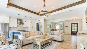 A spacious living room with a large sofa, a coffee table, and a patterned rug. - Tranquility & Nearby Beach Access: Private Oasis (Santa Rosa Beach)