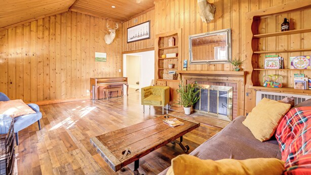 A wooden interior with a fireplace, a sofa, a coffee table, and a dining area. - 4 Mi to Dtwn: Home w/ Fire Pit in Greenville (Greenville)