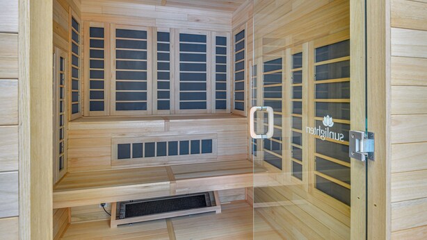 Una sauna con paredes de madera y varias puertas correderas de cristal.