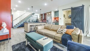 A modern living room with a sofa, ottoman, and a remote control on a table. - 5 Mi to Wec: Pet-friendly Home in Wilmington (Wilmington)
