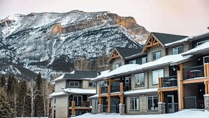 Un hôtel à plusieurs étages, avec une vue imprenable sur les montagnes, doté de balcons et offrant une vue sur les pistes de ski.