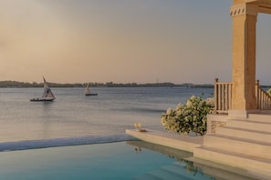 Un área de piscina tranquila con vista despejada al mar y a los barcos.