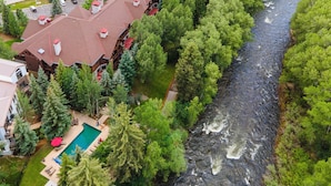 Un hôtel situé au bord de la rivière, composé de plusieurs bâtiments, doté d’une piscine et entouré d’une végétation luxuriante.