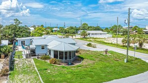 A residential property with a house, a covered patio, and a well-maintained lawn. - Tranquil home w/ firepit near beach (Port St. Joe)