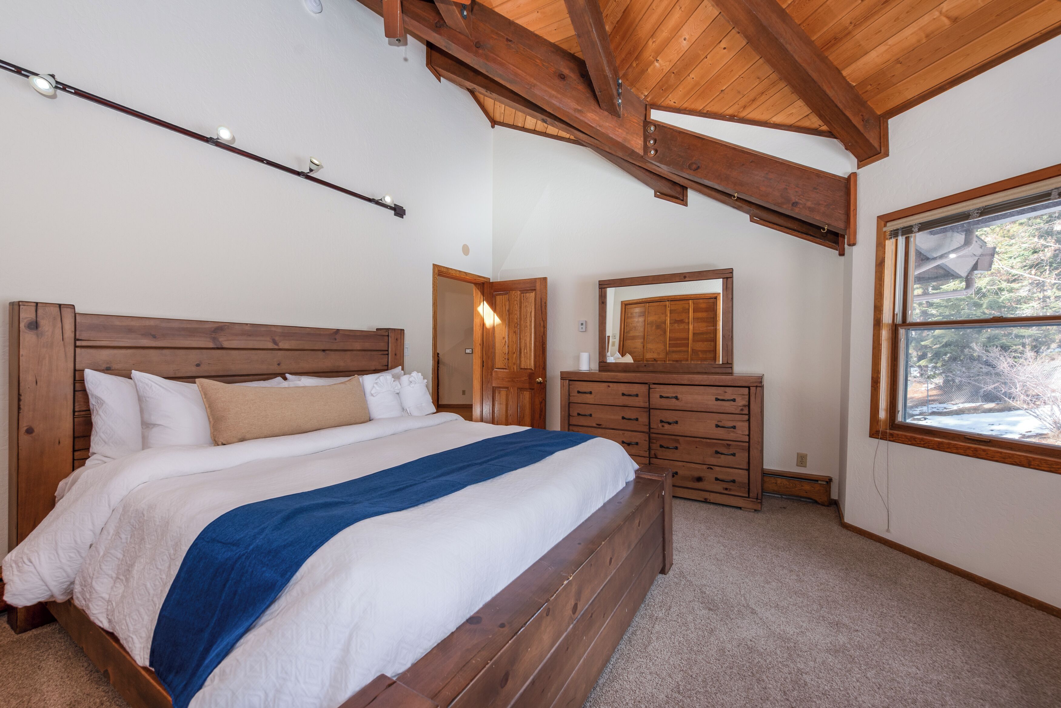 Una camera da letto con un letto in legno, una cassettiera e una finestra.
