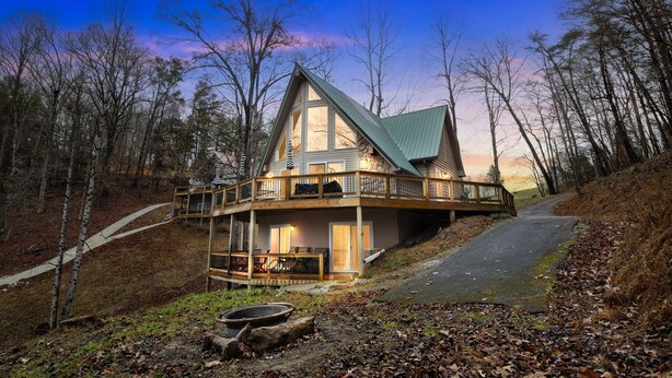A large, multi-story house with a prominent balcony, surrounded by trees and a paved path. - Deerfield Hideaway At Old Rocky 5 Bedroom Home (La Follette)