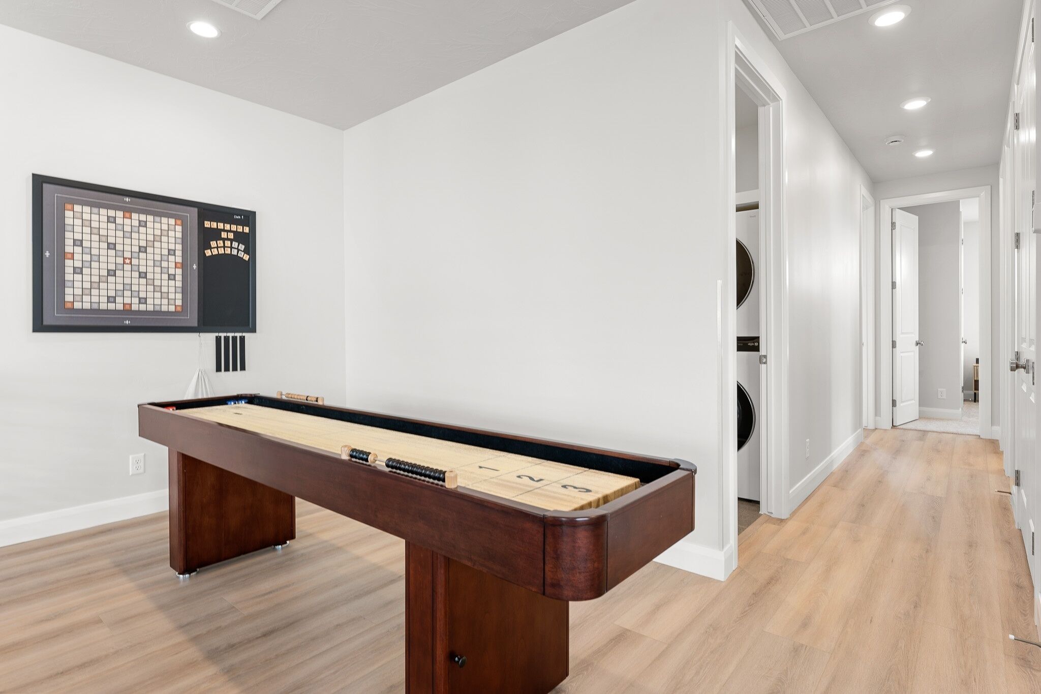 Une table de billard dans une pièce où un tableau blanc affiche les règles d’un jeu.