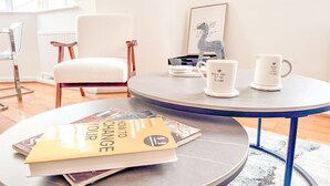 Una habitación moderna con una mesa redonda, una silla, una estantería y un cuadro en la pared.