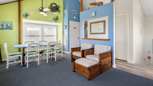Ein Zimmer mit Esstisch und Stühlen, einem Deckenventilator und einem gerahmten Bild an der Wand.