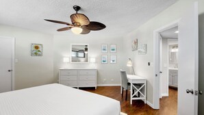 A bedroom with a bed, dresser, desk, and ceiling fan. - Lido Beach Retreat - Book your romantic escape today! (Lido Key)