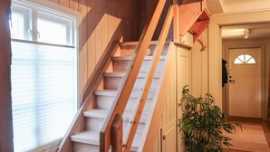 A wooden staircase leading to a landing with a door and a potted plant. - 6 Person Holiday Home in Sondeled (Risør)