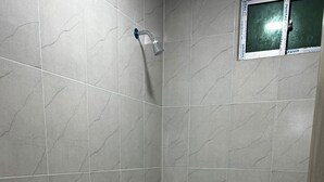 Un baño pequeño con inodoro, ducha y lavabo.