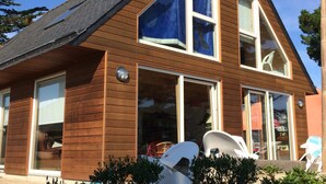 A two-story wooden house with large windows and a sloped roof. - Amazing sea view and large garden for 8 people (Plougasnou)