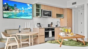 Eine moderne Küche mit Essbereich, einem Flachbildfernseher und einer gemütlichen Sitzecke.