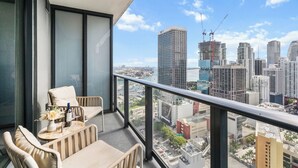 Ein Balkon mit Blick auf eine Stadtlandschaft, darunter Hochhäuser und ein Baukran.
