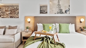 Ein Hotelzimmer mit Bett, Nachttisch, einer Schlafcouch und zwei Wandlampen.