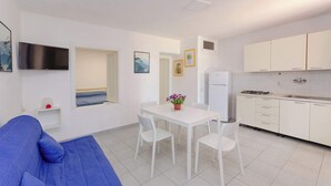 A compact living space with a kitchenette, a dining area, and a sofa. - Villa Lucia - Bilo 4 Mandarin - ground floor (Puglia)