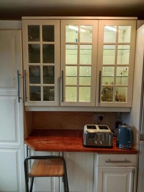 A kitchen with white cabinets, a wooden countertop, a toaster, and a kettle. - London - Waterfront House - Stay8 - Parking - Yard (London)