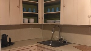 A kitchen with white cabinets, a sink, and a countertop. - Desirable Elmwood location. Tudor style garage apt studio w/central heat& a/c. (Abilene)