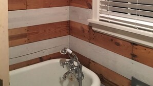A bathroom with wooden paneling, a white sink, and a window with blinds. - Desirable Elmwood location. Tudor style garage apt studio w/central heat& a/c. (Abilene)