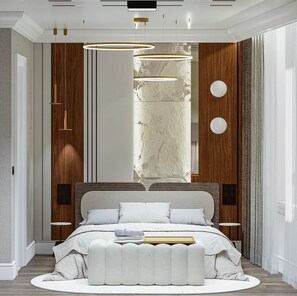 Cozy retreat with a central bed, circular ottoman, and pendant lights.