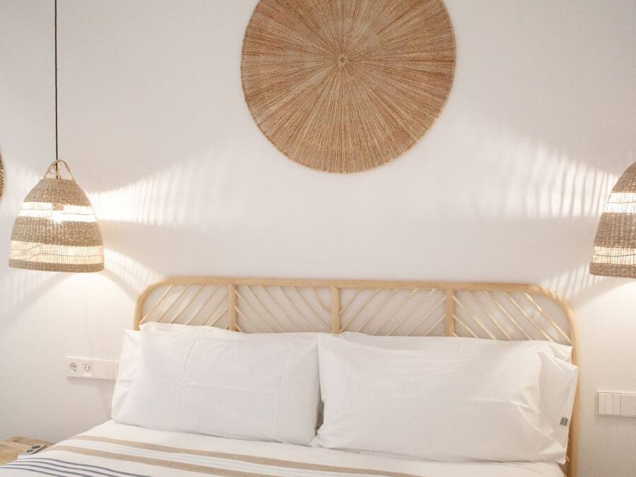 Un dormitorio con cama, dos lámparas de noche y un adorno circular en la pared.