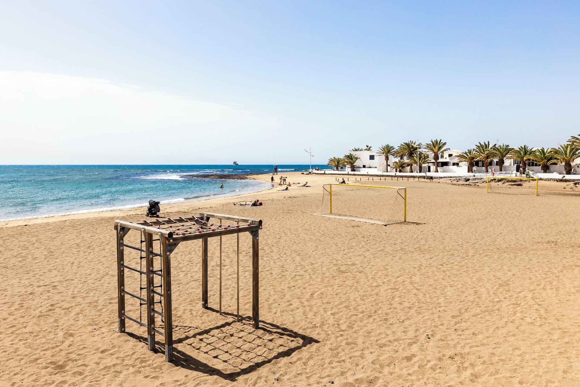 Ein Strand mit einem Volleyballnetz und einem kleinen Tisch.
