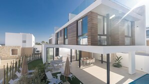 A modern two-story house with a swimming pool, outdoor seating, and a well-maintained garden.