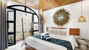 Un dormitorio moderno con una cama grande, una pared de piedra y un techo de madera.