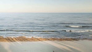 A beach with calm water and a sandy shore. - Juniper Presents: Beach Bliss Home with Rooftop Deck & Pool Access (Union Pier)