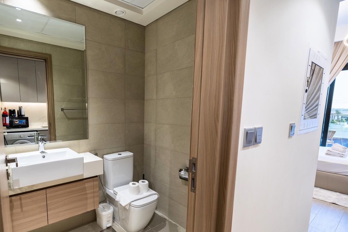 Une salle de bain moderne équipée d’un lavabo, de toilettes et d’une douche.
