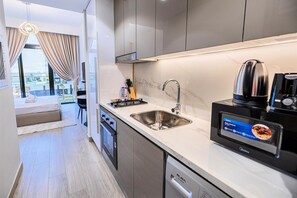A modern kitchen with a built-in dishwasher, a coffee machine, and a digital menu display.