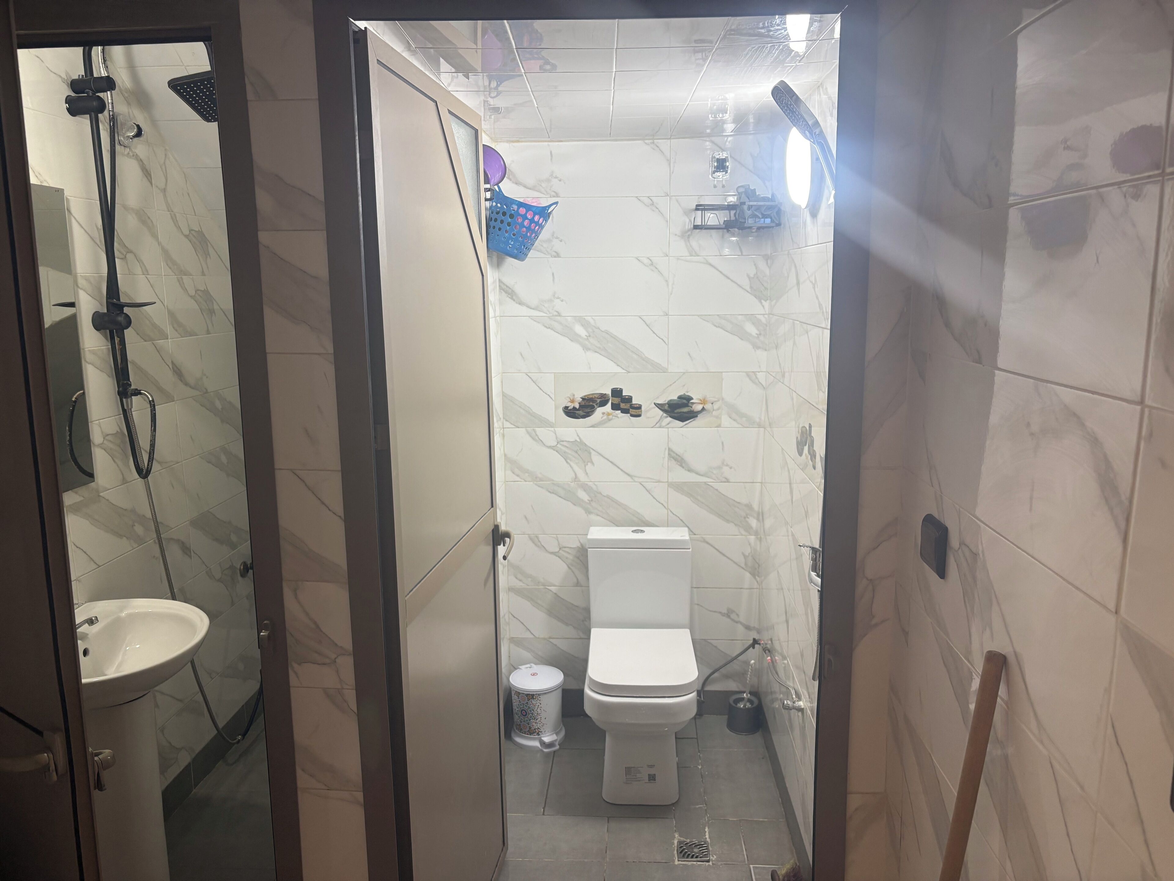 Ein Badezimmer mit Dusche, Toilette und Waschbecken.