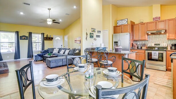 A modern kitchen with wooden cabinets, a stainless steel refrigerator, and a built-in oven.