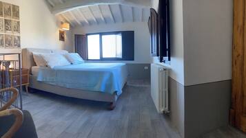 A bedroom with a bed, a chair, a window, and a radiator.